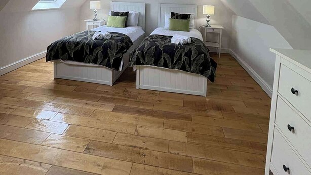 A bedroom with two beds, a skylight, and a white dresser. - Modern Apartment - Quiet Location (Doncaster)