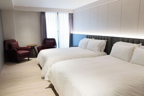 A hotel room with two beds, a small table, and two armchairs. - TALMUD HOTEL CLASSIC TAIWAN BOULEVARD (Taichung)