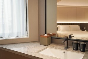 A hotel bathroom with a sink, mirror, and toiletries. - TALMUD HOTEL CLASSIC TAIWAN BOULEVARD (Taichung)