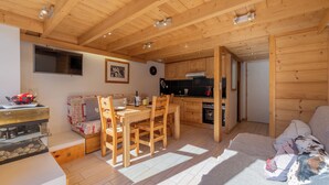 A cozy wooden interior with a dining area, kitchen, and living space. - Grand Roc A215 150m from Slopes, Mountain View & Parking, Argentière (Chamonix), France (Argentière (Chamonix))