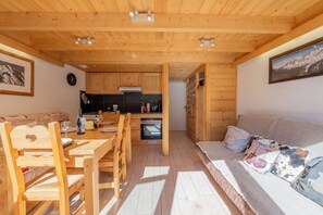 Um interior de madeira acolhedor com sala de jantar, cozinha e área de estar.