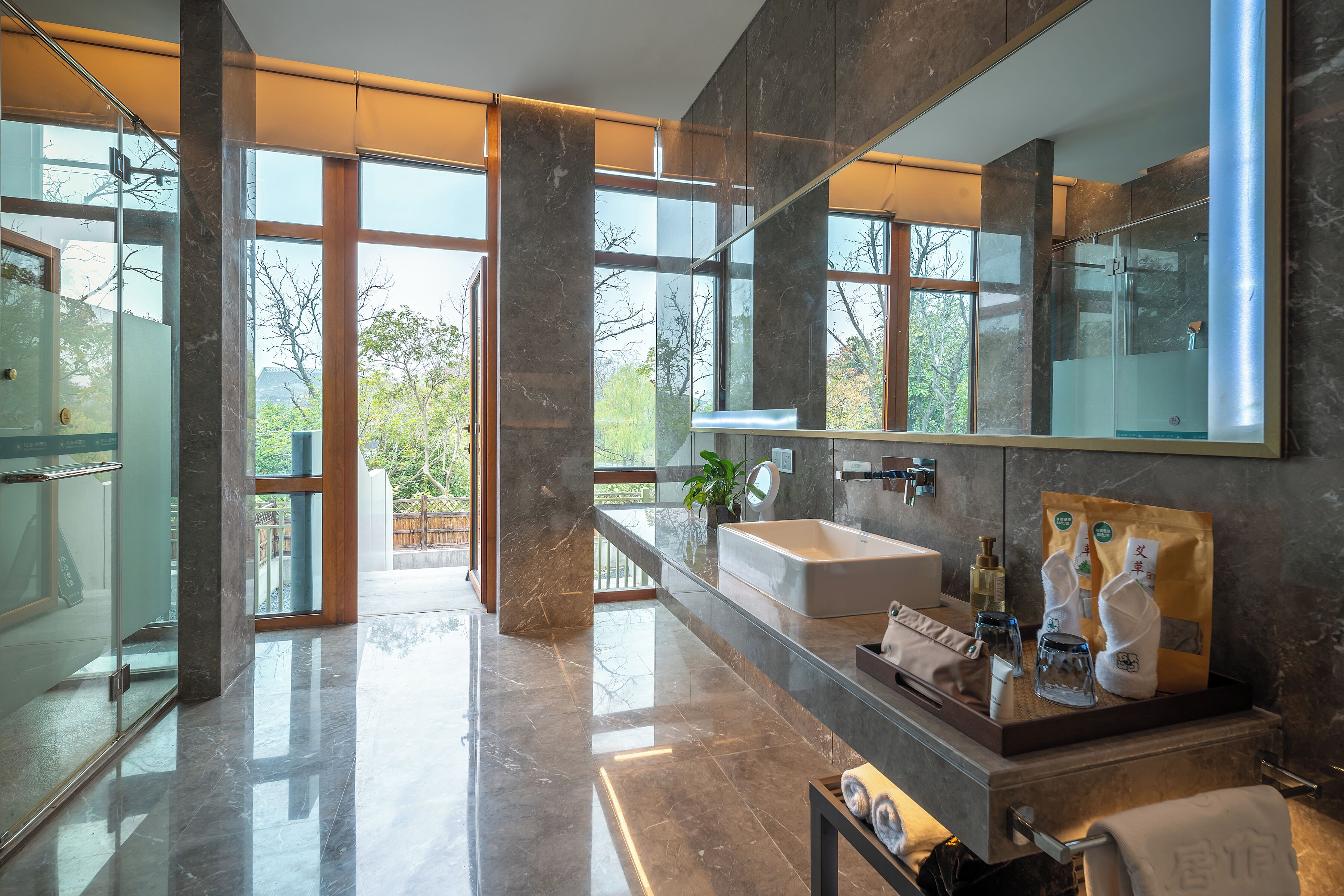 Un baño moderno con un espejo grande, un lavamanos y una cabina de ducha de vidrio.