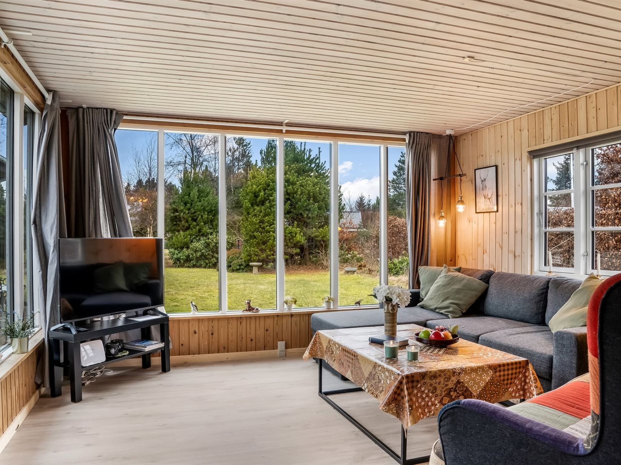 Ein gemütliches Wohnzimmer mit einer Couch, einem Couchtisch und einem Fernseher.