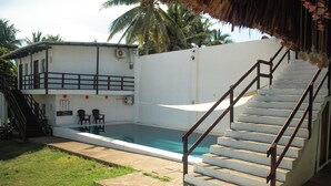 Une piscine avec un escalier menant à un balcon.