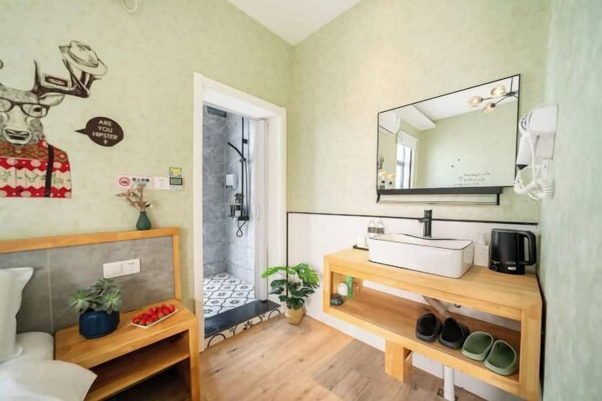 Un baño con lavamanos, espejo y ducha.