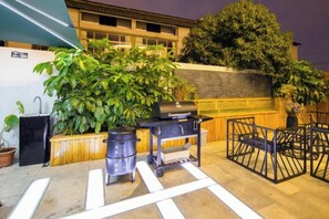 An outdoor patio area with a grill, potted plants, and a seating area. - Shanghai Qichi homestay (Shanghai)