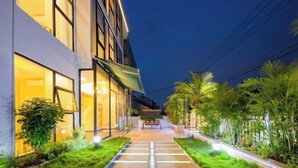 A pathway leading to a building with glass doors and a green awning. - Shanghai Qichi homestay (Shanghai)