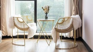 A room with two gold-framed chairs, a small round table, and a vase with flowers. - Shanghai Qichi homestay (Shanghai)
