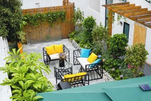 An outdoor patio with a seating area, a pergola, and various plants. - Shanghai Qichi homestay (Shanghai)