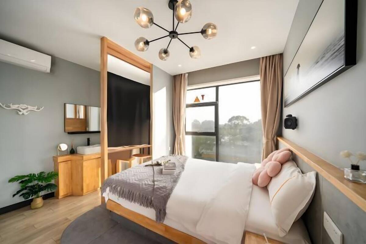 Un dormitorio moderno con cama, mesita de noche y un amplio ventanal.