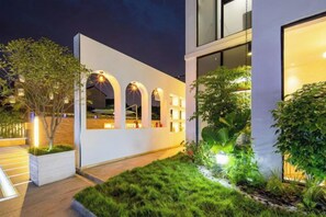 A modern building with a white facade, arched windows, and a well-lit entrance. - Shanghai Qichi homestay (Shanghai)
