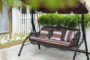 A wicker outdoor seating area with a cushioned bench and a canopy. - Shanghai Qichi homestay (Shanghai)