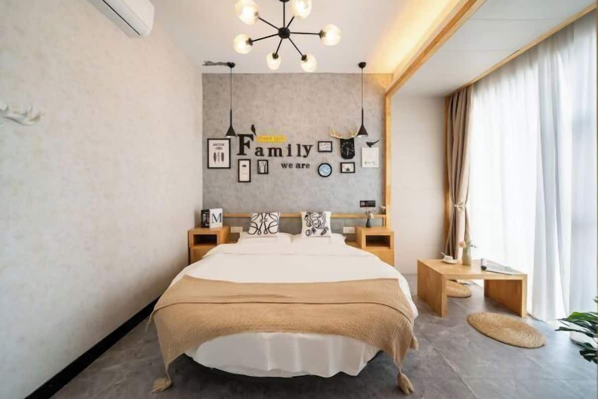Un dormitorio con una cama, mesitas de noche, una lámpara de pared y una pared decorada con fotografías y texto.