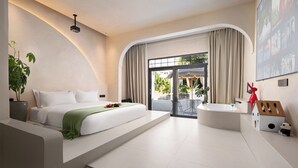 Ein modernes Hotelzimmer mit einem großen Bett, einer Badewanne und einem Balkon mit Vorhängen.
