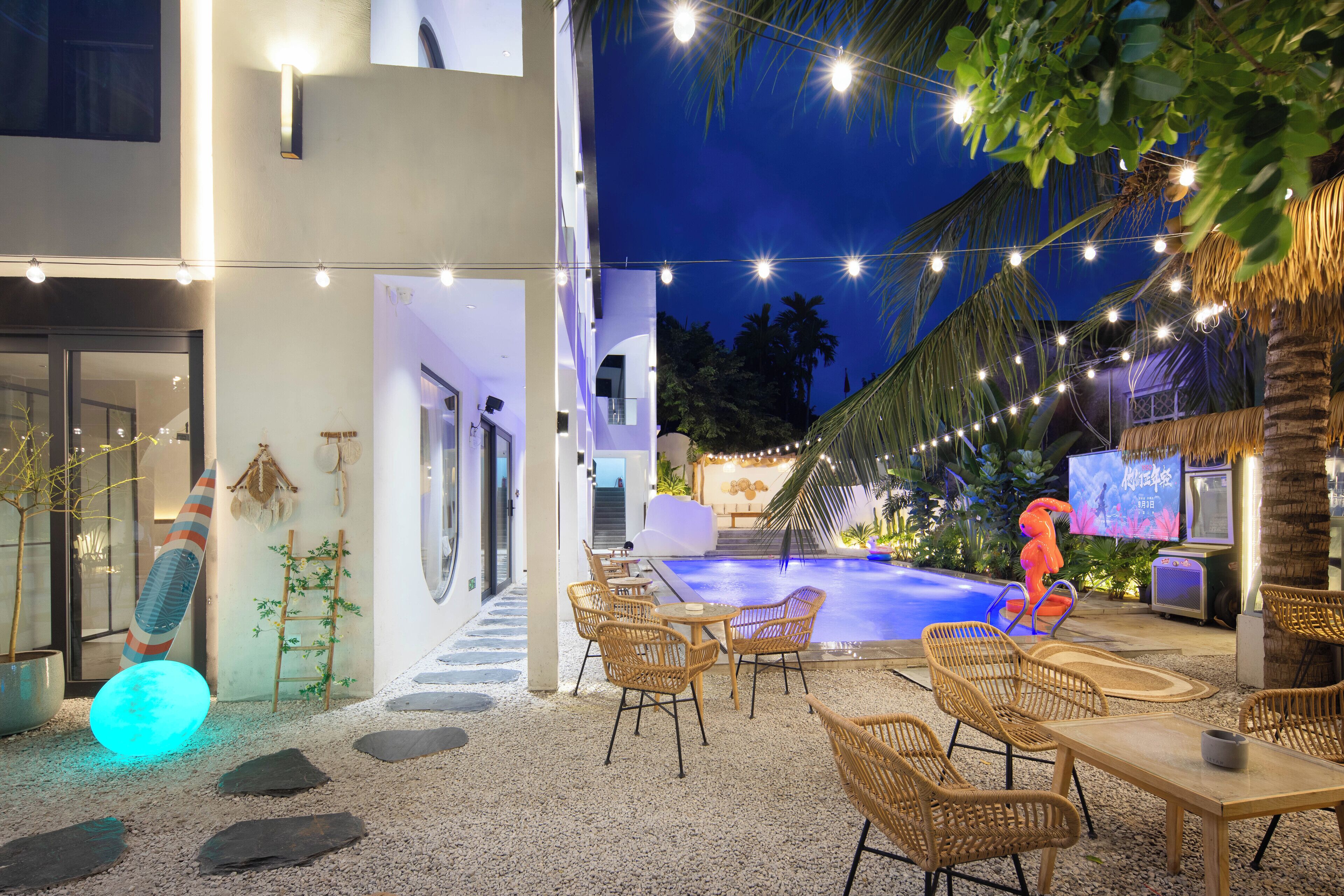 An outdoor pool area with lounge chairs and a tiki bar.