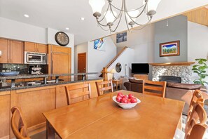 Une cuisine moderne avec des meubles en bois, un four à micro-ondes et un coin repas comprenant une table et des chaises.