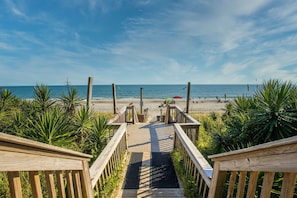A wooden boardwalk leading to a beach with palm trees and a clear sky. - Seabatical Oceanfront: In & outdoor pools, hot tub, sauna, gym #203 (Atlantic Beach)