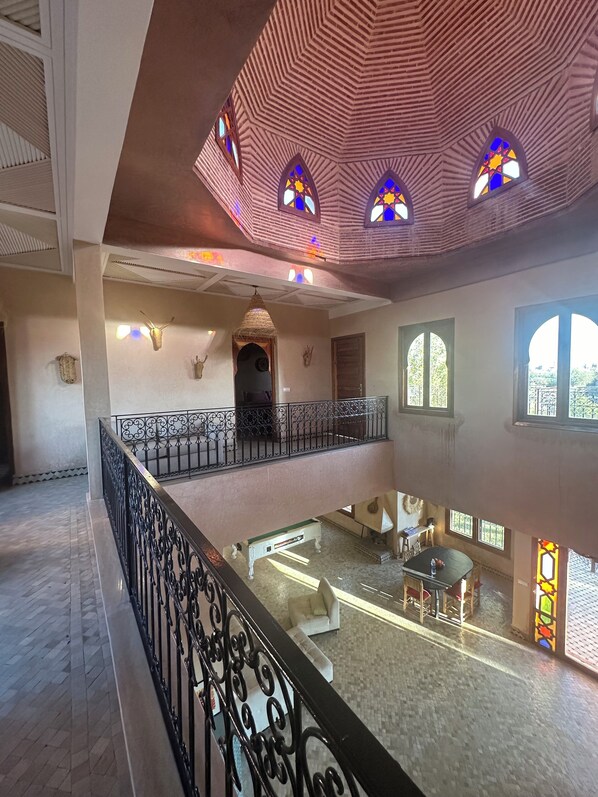 A spacious interior with a high ceiling, multiple windows, and a balcony with ornate railings. - Exceptional villa with swimming pool-Marrakech countryside (Marrakech)