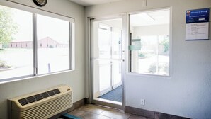 L’entrée d’un motel, avec une porte, une horloge et un panneau indicateur.