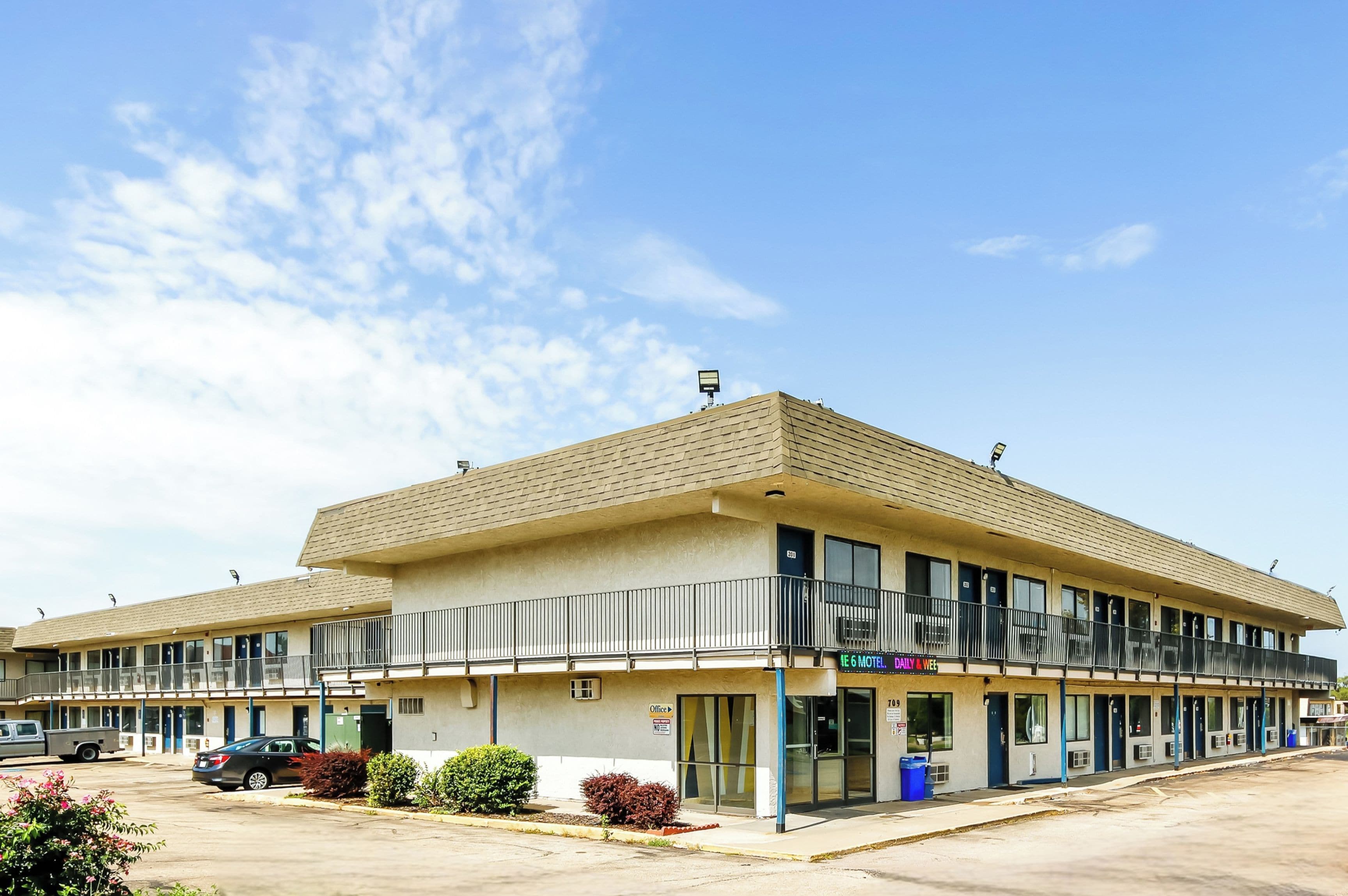 Un motel composé d’un bâtiment à deux étages, de plusieurs chambres et d’un parking.