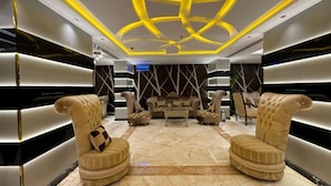 A luxurious living room with high-end furniture, a marble floor, and a unique ceiling design. - Aseel Almisk Hotel (Makkah)