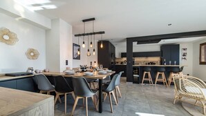A modern kitchen with a central island, black bar stools, and pendant lighting. - Sylodges 202 - Spacious apartment for 10/12 people (LA TOUSSUIRE)