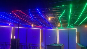A pool table in a dimly lit room with colorful LED lights along the ceiling and walls. - The CEO hotel and suite  (Ibadan)