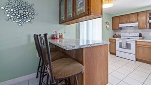 A kitchen with wooden cabinets, a granite countertop, and a built-in stove. - Waterfront Angler’s Paradise, 3BR/2.5BA w/ Dock, Boat Ramp, Kayaks, HorseShoes, CornHole, Ping Pong (New Port Richey)