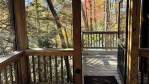 Une terrasse en bois offrant une vue sur une zone boisée.