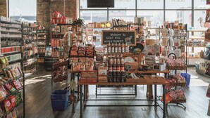 Een markt met diverse etenswaren, waaronder verpakte producten en vers fruit en groenten.