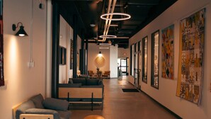 A modern interior with a long hallway, a sofa, a round table, and wall art. - Duluth Craft Loft | Dog-Friendly (Duluth)