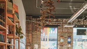 A spacious art studio with wooden floors, shelves with art supplies, and easels set up for painting. - Duluth Craft Loft | Dog-Friendly (Duluth)