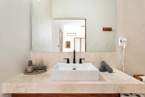A bathroom with a white sink, a large mirror, and a towel rack.