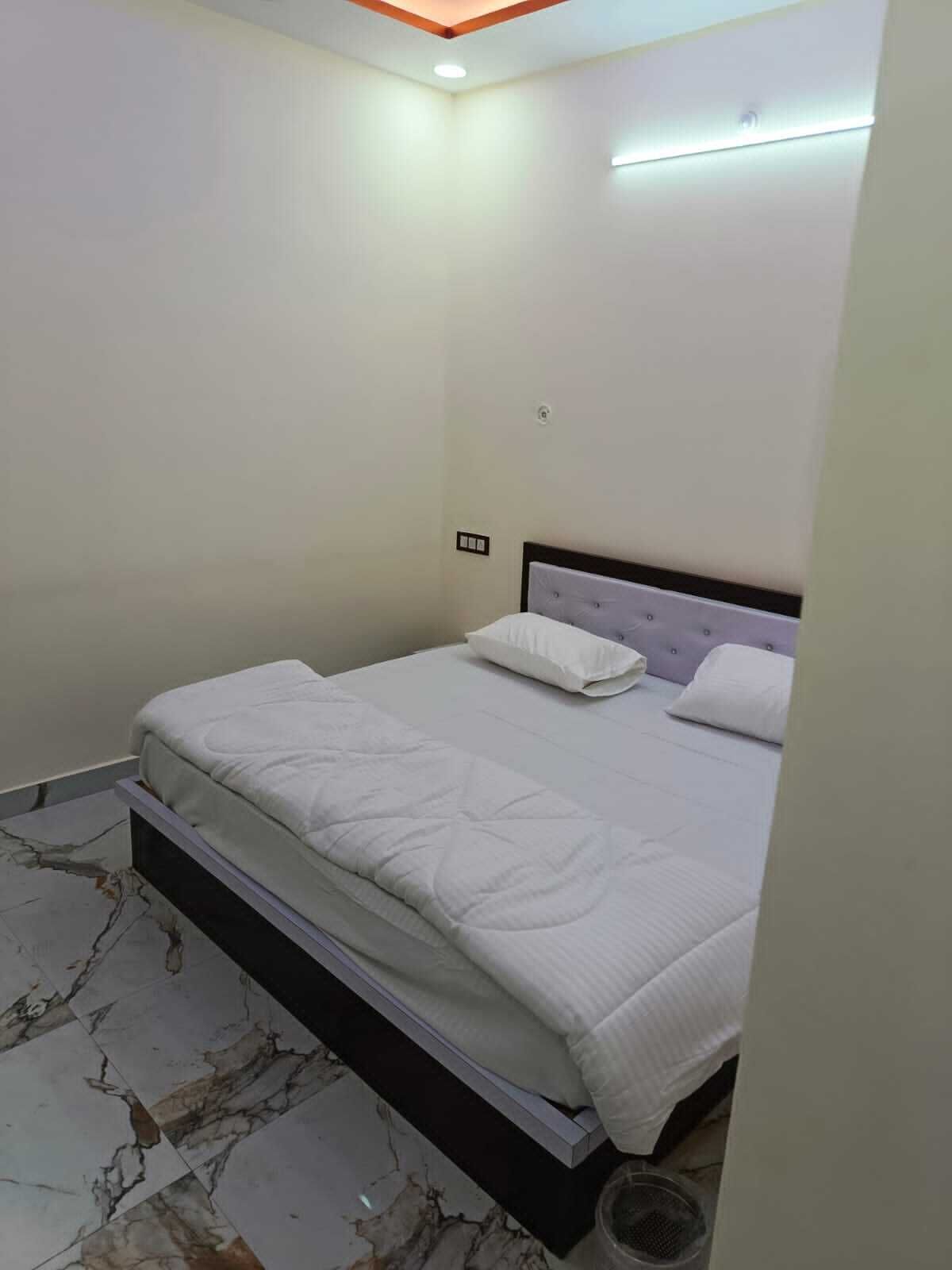 Ein Schlafzimmer mit einem Bett, weißen Wänden und einem Boden mit Marmoroptik.