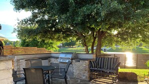 An outdoor patio with stone flooring, a grill, and seating. - Charming Pond Villa 3-bedroom 2 Bath house DFW (Grand Prairie)