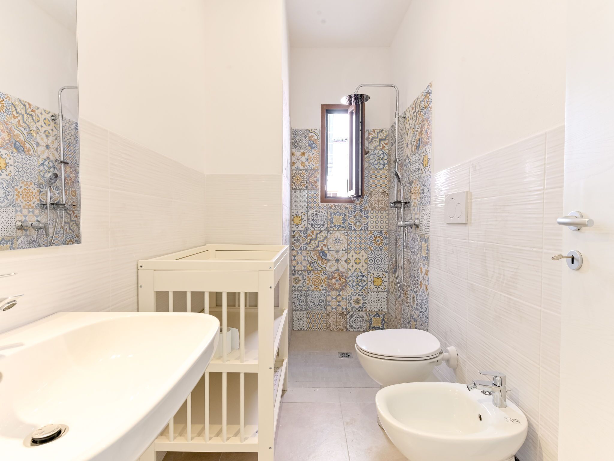 A bathroom with a white sink, a toilet, and a shower area.