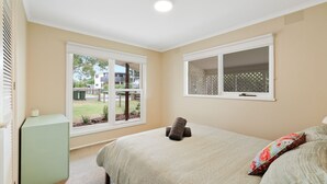 A bedroom with a bed, a window, and a small table. - Avalon Cape Woolamai (Cape Woolamai)