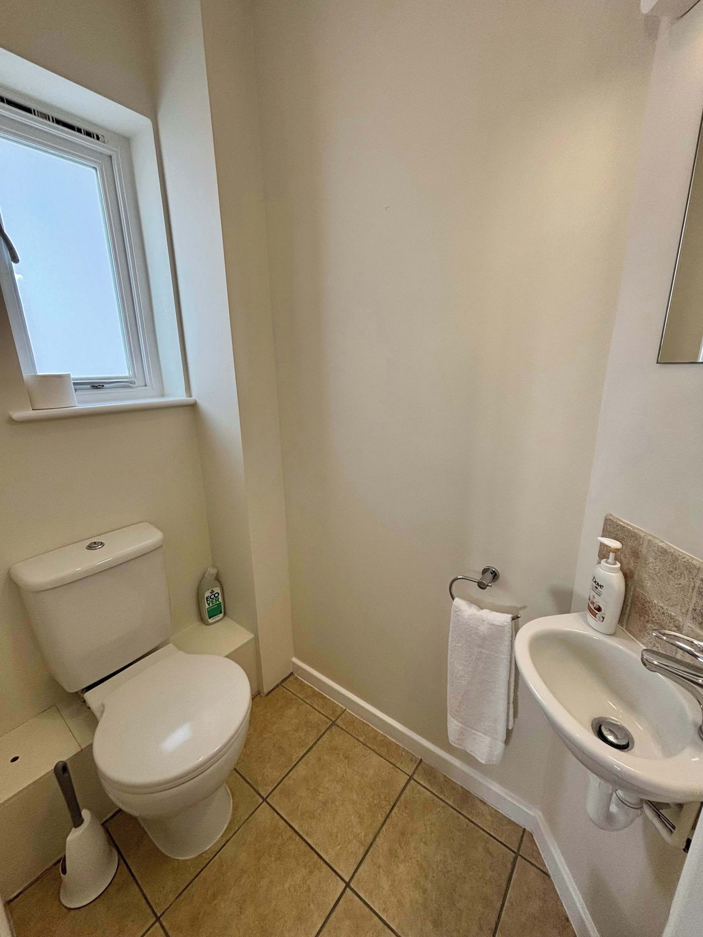 Un bagno con il water, bidet, lavandino e una finestra.