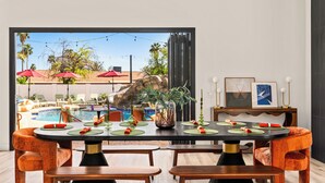 A dining area with a view of a pool and outdoor seating. - Bespoke Playhaus of Scottsdale: Open Sky Estate (Scottsdale)