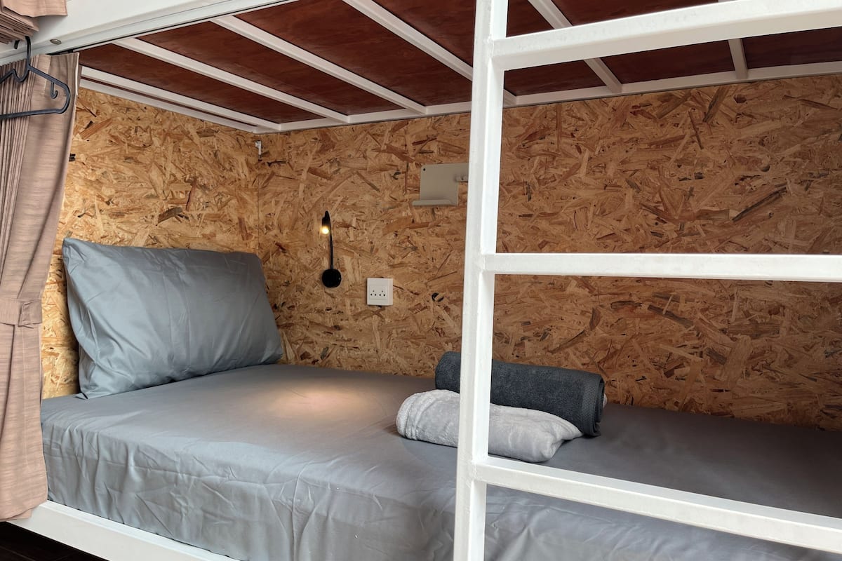 Ein Schlafraum mit Etagenbetten, Holzwänden und einer weißen Decke.
