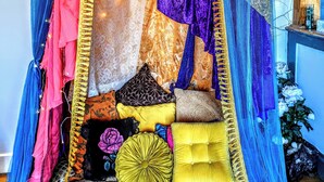 Una cama con dosel, varios cojines y un cabecero decorativo.