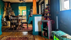 Una sala de estar acogedora con chimenea, muebles de madera y una pared verde.