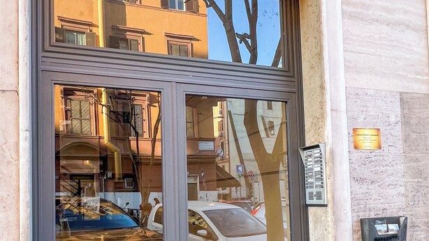 A hotel entrance with a large glass door, a tiled floor, and a visible parking area. - Stylish 2-Bedroom Flat by St. Peter’s – King Bed, A/C, Fast Wi-Fi. Super Clean! (Roma)