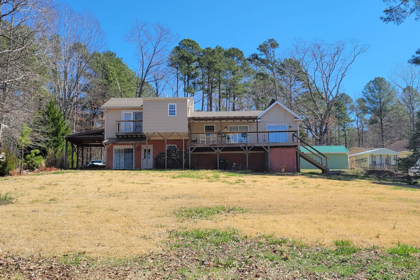 A two-story house with a covered porch, a garage, and a small detached building.