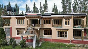 A two-story building with a balcony, a staircase, and a sign that reads "Lamas Ecological Lodge".