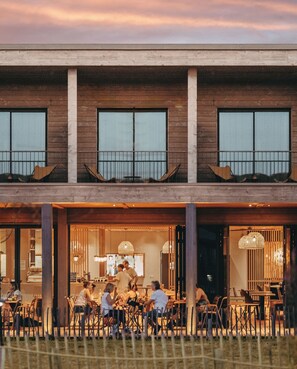 A modern building with a dining area visible through large windows. - Auberge Le Bout du Parc (Versailles)