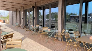 Enjoy dining or socializing in the outdoor seating area with tables and chairs on a spacious deck.