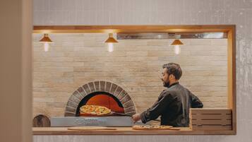 Eine Ziegelwand mit einem holzrahmenfenster über einem Pizzaofen.