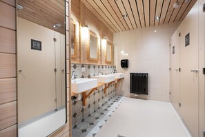 Three sinks with individual mirrors and a heated radiator are featured in this restroom.