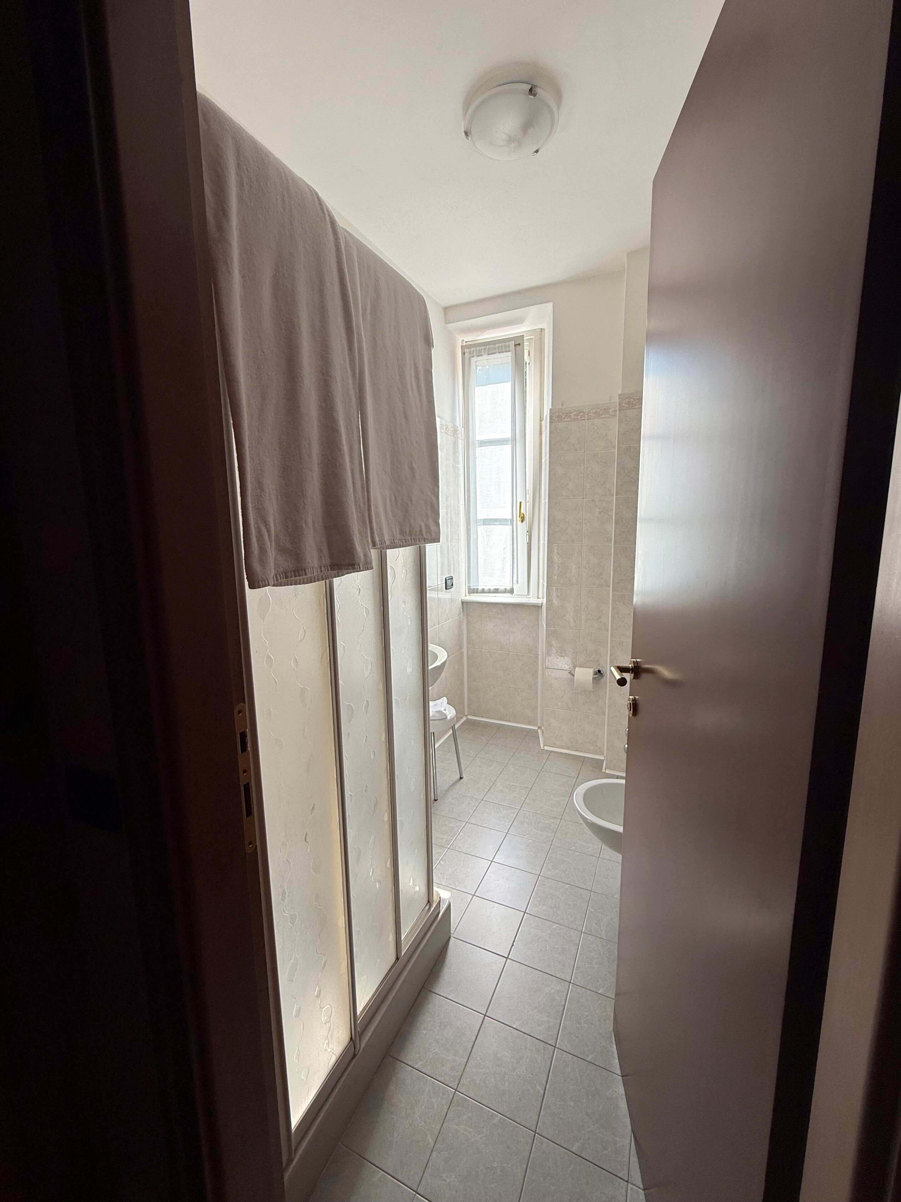 A bathroom with a shower, toilet, and sink.